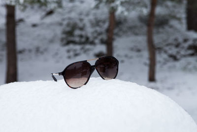 Close-up of sunglasses on snow