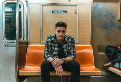 Full length of man sitting in train