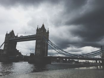 Low angle view of tower bridge against cloudy sky