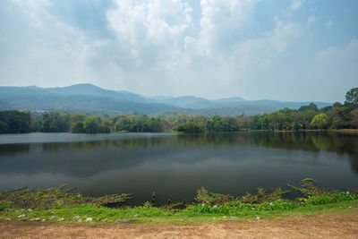 Scenic view of lake by trees against sky