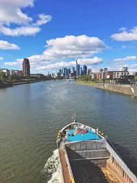 Scenic view of river by city against sky