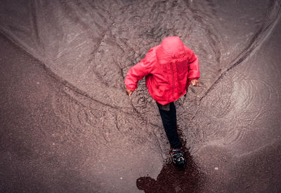 High angle view of boy walking in water outdoors