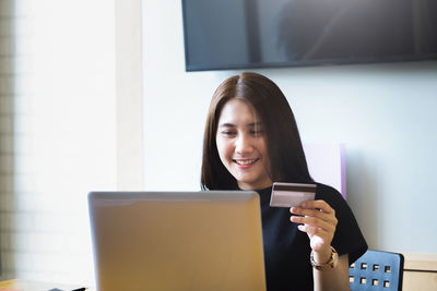 Portrait of a smiling young woman using smart phone