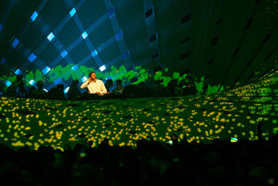 Group of people by illuminated lights at night