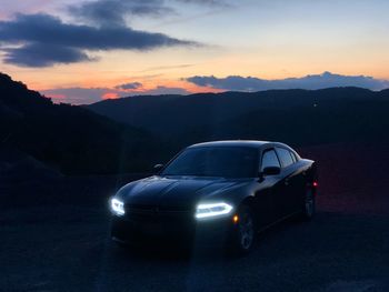 Car on street against sky during sunset