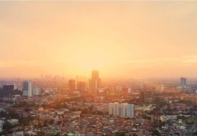 HIGH ANGLE VIEW OF CITYSCAPE AGAINST SKY DURING SUNSET