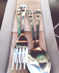 Close-up of eating utensils with anthropomorphic faces on table