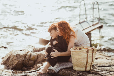 Woman sitting on wicker basket at beach