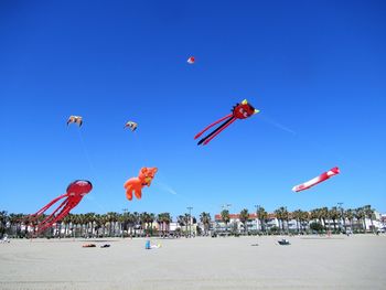 Low angle view of kites flying in sky