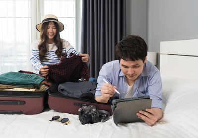 Young woman using digital tablet while sitting at home