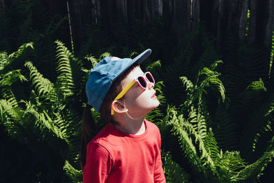 Happy child looking up at the sun in sunglasses and a cap. the concept of mental health, self-care 