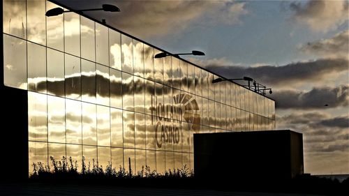 Low angle view of silhouette building against sky at sunset