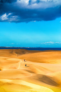 Scenic view of dunes at maspalomas with two people 