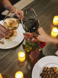 Midsection of people holding glass of table