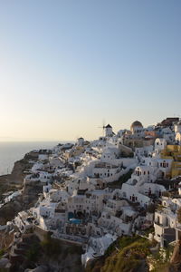 Aerial view of townscape by sea against clear sky