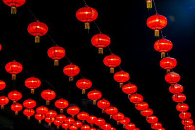 Low angle view of illuminated lanterns hanging at night