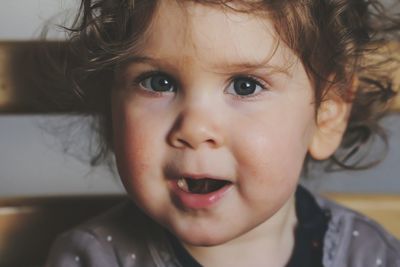 Close-up portrait of cute baby girl sitting on chair