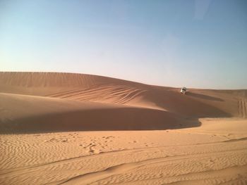 Scenic view of desert against blue sky