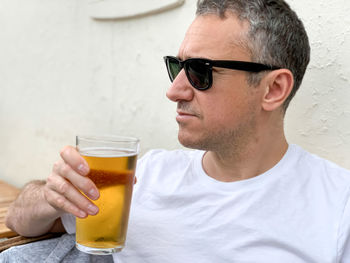 Middle aged man is drinking beer in a cafe or restaurant pub outdoor. drinking alcohol lager or ale