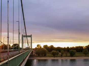 Bridge over river against sky during sunset