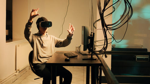 Side view of man using mobile phone while standing in factory