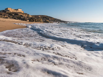 Scenic view of beach against clear sky