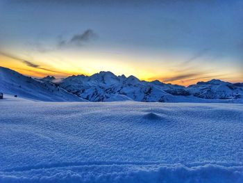 Scenic view of snowcapped mountains against sky during sunset