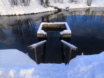 Wooden structure in lake during winter