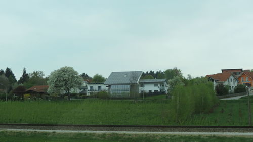 Houses on field against clear sky