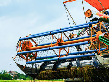 Low angle view of combine harvester against sky