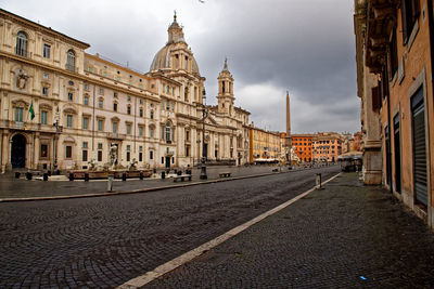 Street amidst buildings against sky in city