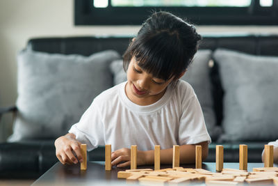 Girl playing with toy blocks on table