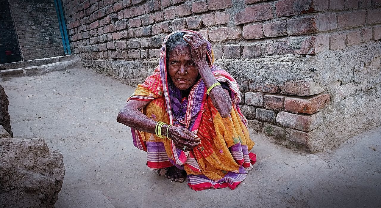 PORTRAIT OF WOMAN AGAINST WALL