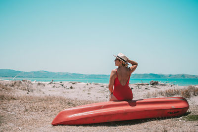 Man wearing hat on beach against clear sky