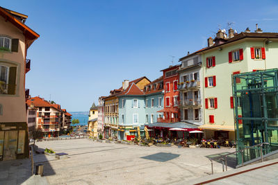 Street amidst buildings in city against clear sky