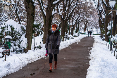 Full length of woman standing on snow covered trees