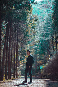 Portrait of man standing amidst forest