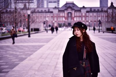 Portrait of woman standing on street in city