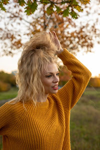 Portrait of young woman looking at tree