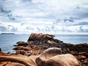 Rocks on beach against sky