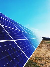 Low angle view of solar panels on field against sky