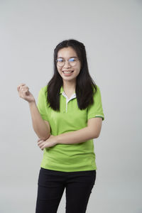 Portrait of smiling young woman against white background