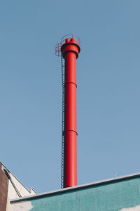 Low angle view of smoke stack against blue sky