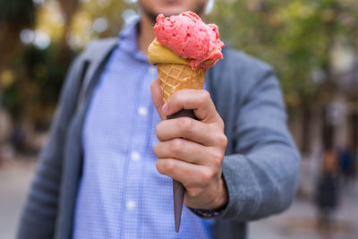 Midsection of man holding ice cream