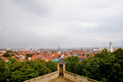 View of cityscape against cloudy sky