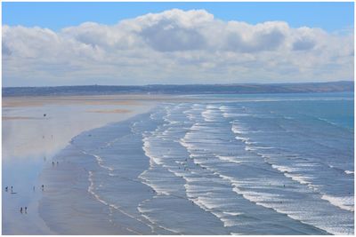 Scenic view of shore at beach against sky