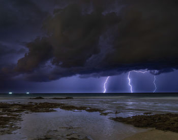 Scenic view of sea against storm clouds