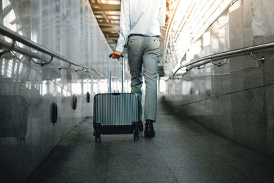 Low section of man walking at airport