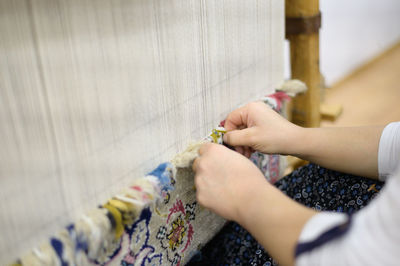 Close-up of woman working on loom