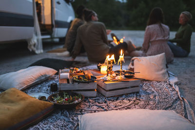 Female and male friends talking by camping van during vacation